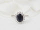 Bague marguerite en or blanc, diamants et saphir ovale 58 Facettes 26804