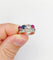 Bague 51 Bague jarretière Art déco en or blanc 18k, diamants, saphir et rubis 58 Facettes A03240