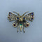 Broche Broche en or jaune 14 ct, argent, diamants et pierres de couleur 58 Facettes