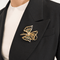 Broche Broche nœud stylisé en or jaune 18 carats, diamants et émeraudes 58 Facettes 36314