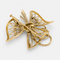 Broche Broche nœud stylisé en or jaune 18 carats, diamants et émeraudes 58 Facettes 36314