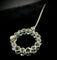 Broche cercle en or blanc, diamants et émeraudes naturelles 58 Facettes broche 1
